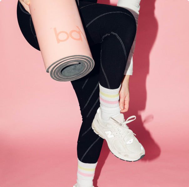 Girl on the go to yoga class with her sneakers and her retro pilates socks from buttr form